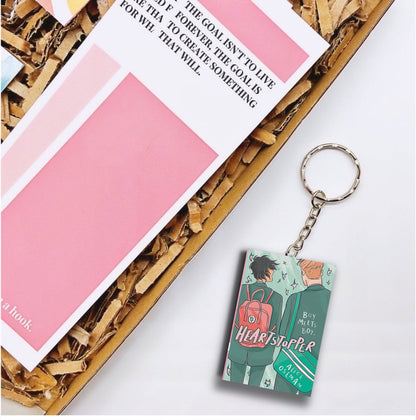 A keyring that is a miniature of the book Heartstopper volume 1.