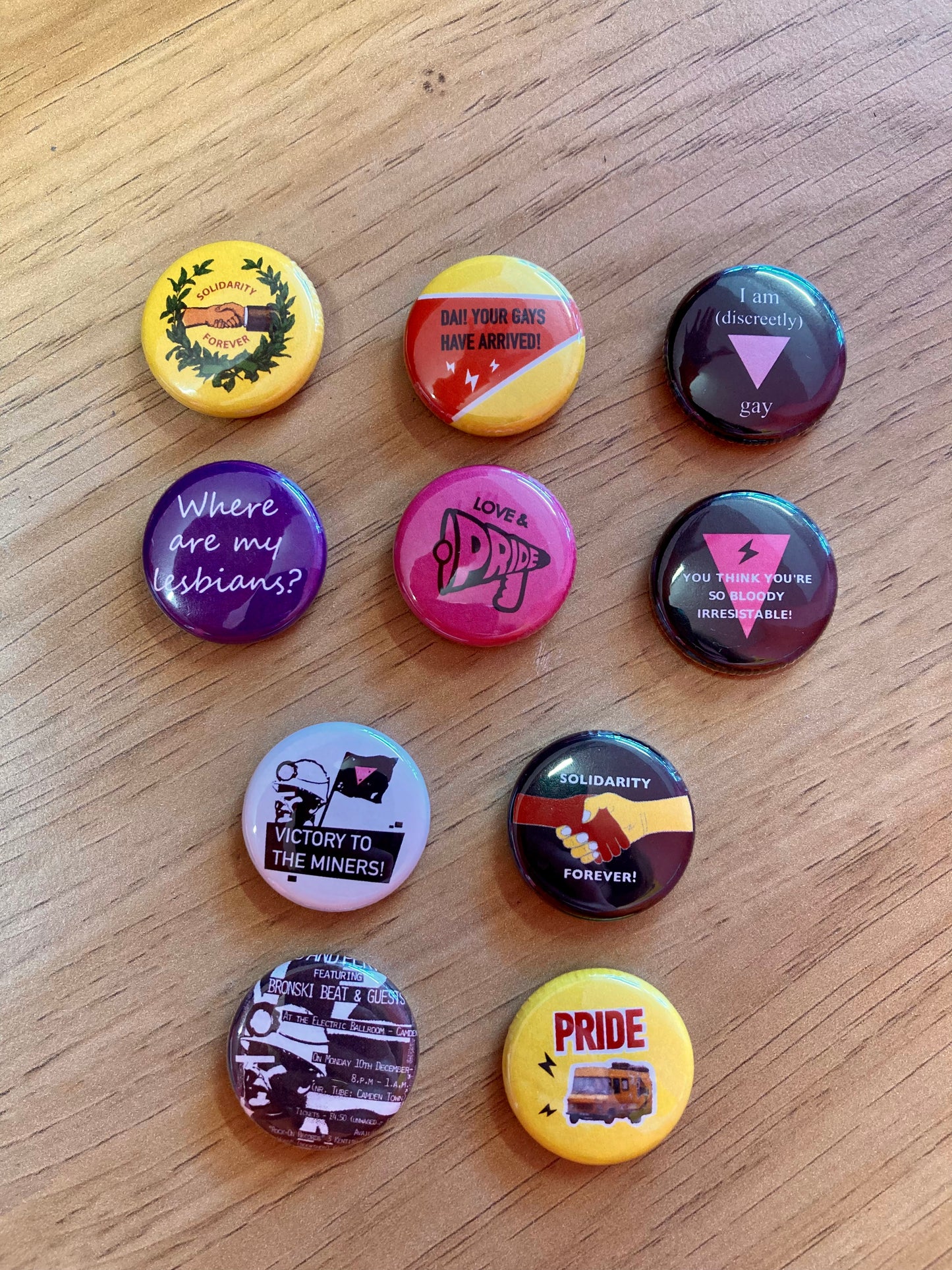 A selection of retro pride badges with references to the film Pride and the activist group Lesbians and Gays Support the Miners.