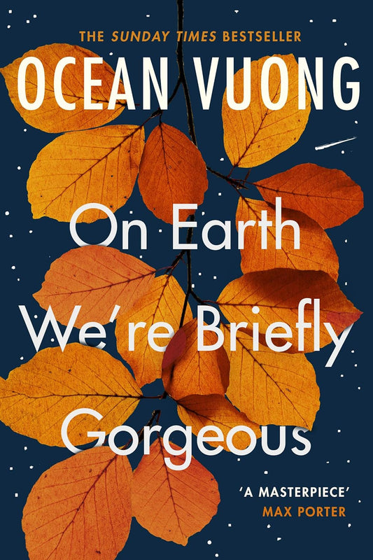 The dark blue book cover for On Earth We're Briefly Gorgeous has a branch covered in orange leaves behind the white text of the title.