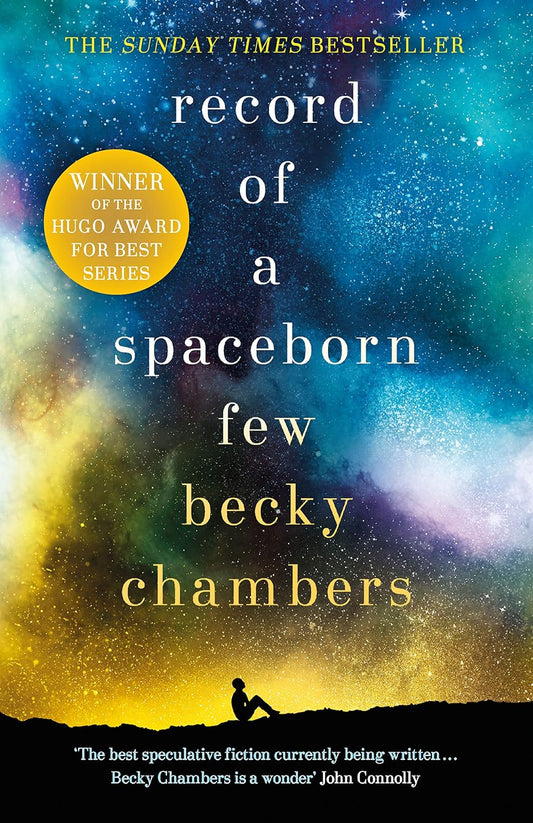 The book cover for Record of a Spaceborn Few shows a figure sat on a mountain top looking up at the billions of stars in the sky, hues of yellow and blue making up the galaxy.