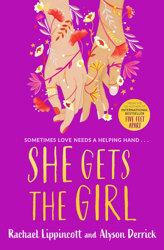 The book cover for She Gets the Girl shows two hands touching with flowers wrapped around them. The tagline in purple text reads "Sometimes love needs a helping hand ..."