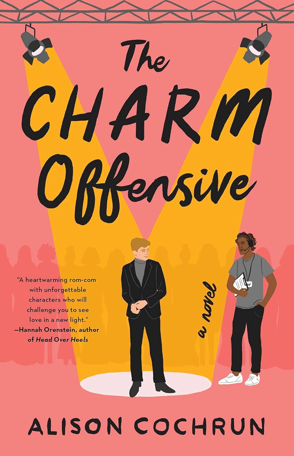 The book cover for The Charm Offensive shows a white man in a suit stood centre stage with a spotlight shining down on him. To the right of the stage is a brown man dressed in plain clothes and wearing a headset. Behind them is the outline of a row of women.